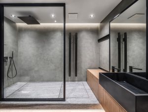 Glass shower doors that are framed with black-painted steel